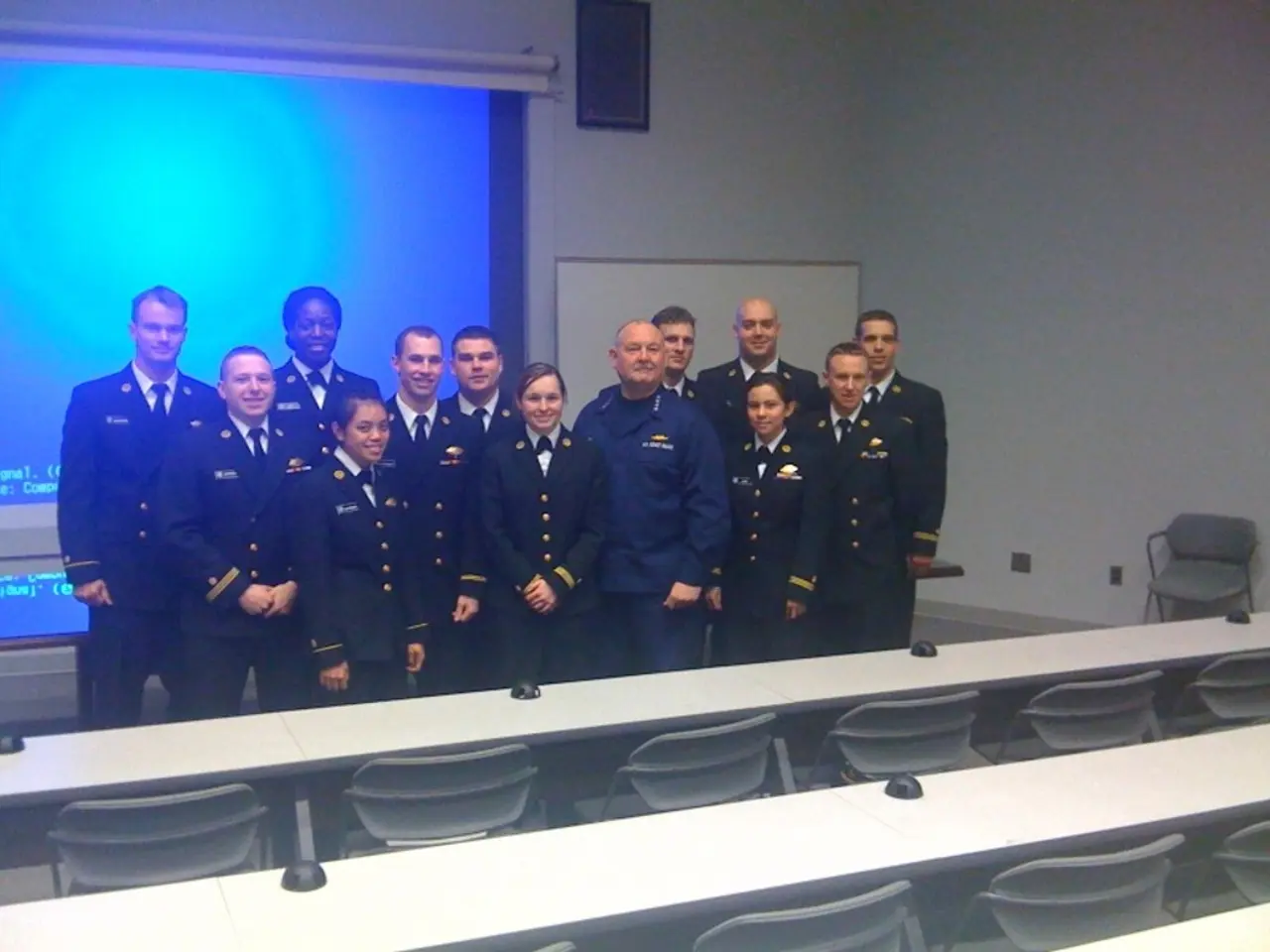 In the picture we can see some group of people standing in the uniforms with black color blazers,...