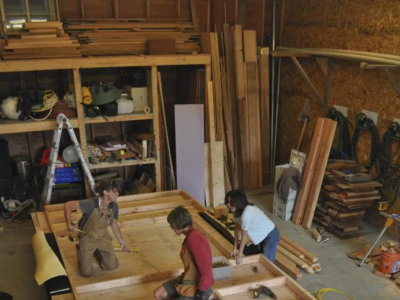 In this picture we can see a carpentry workshop with people working inside it.