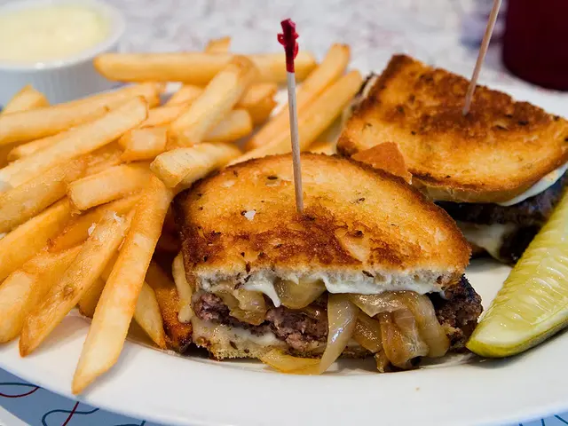 This image consists of a plate. It is in white color. It has some eatables. There are french fries,...